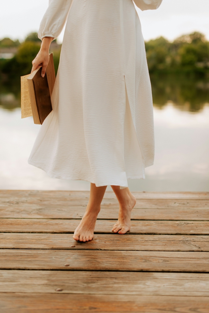 Nő sétál egy vízparti stégen