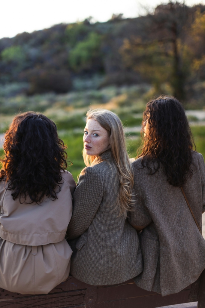 Barátnők háttal ülnek, kivéve egyet, aki hátra fordul