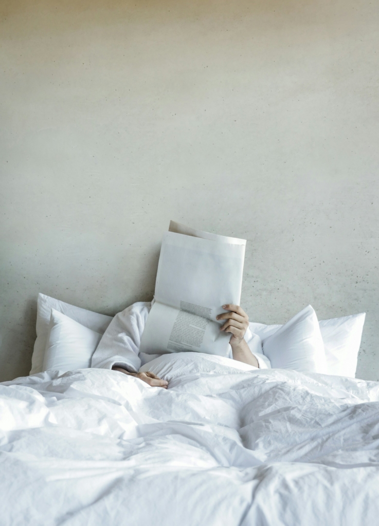 Donna legge il giornale a letto dopo il risveglio