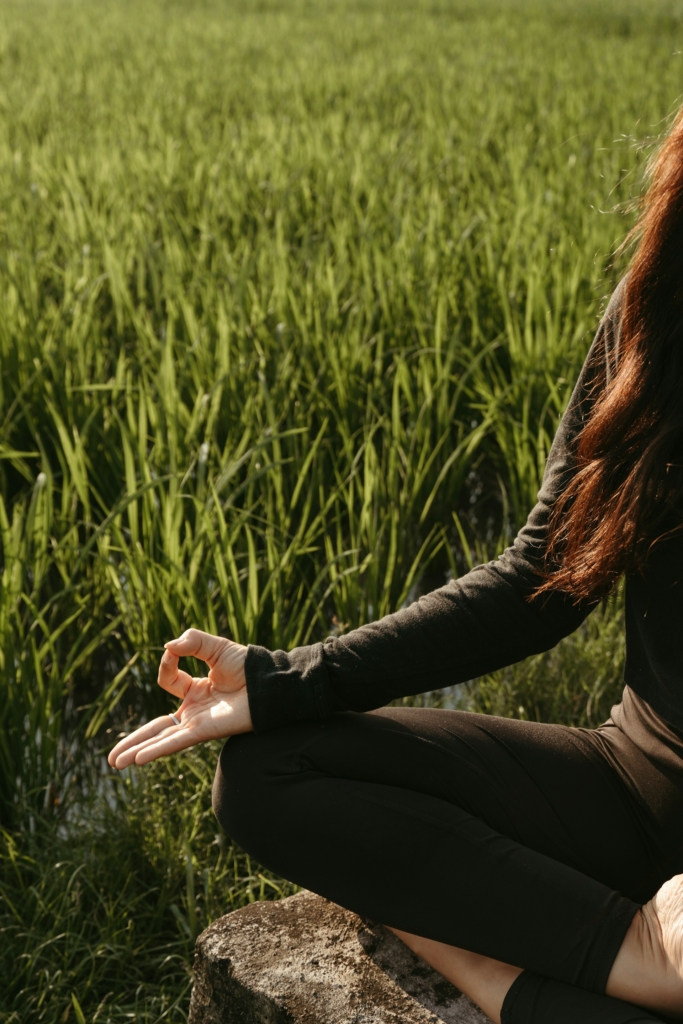 Nő meditál a fűben ülve