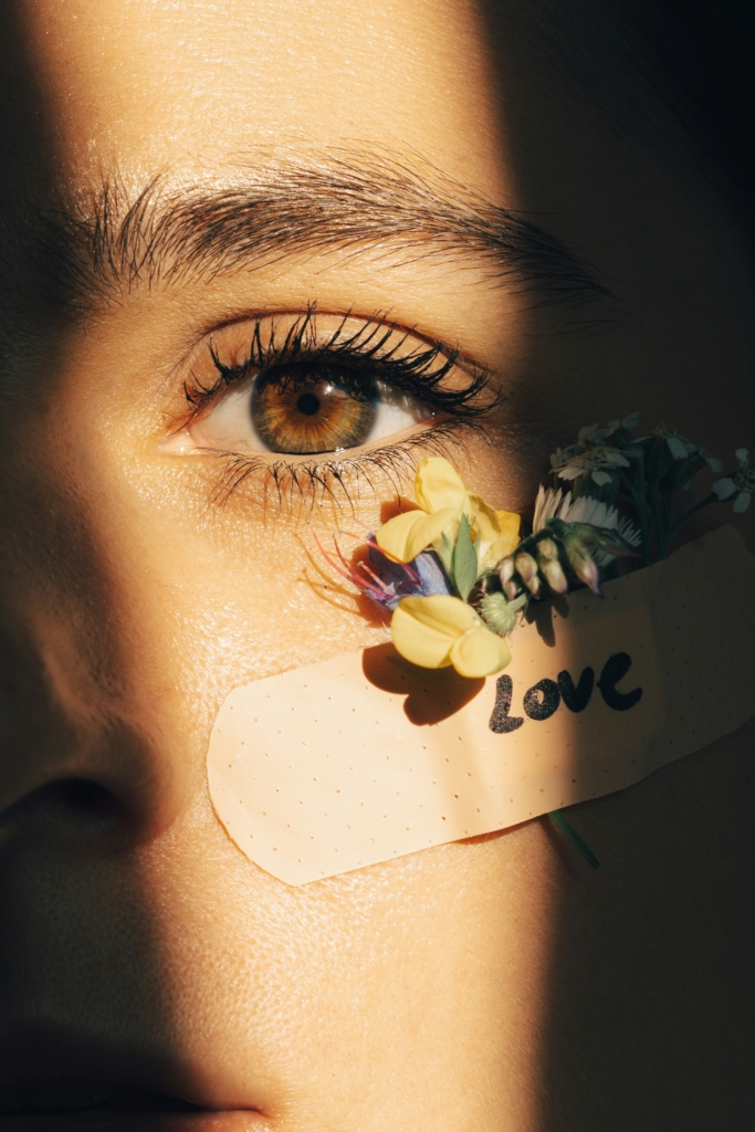 Női szem közelről, alatta sebtapasz Love felirattal