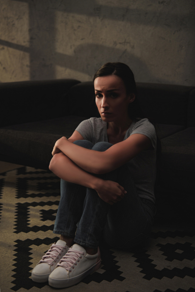 Depressziós nő ül a sötétben a földön