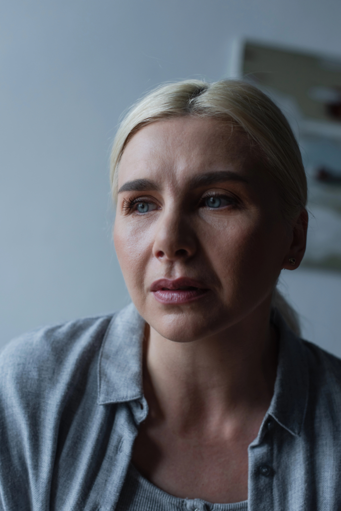 Szőke nő szomorúan, elgyötört arckifejezéssel, portré