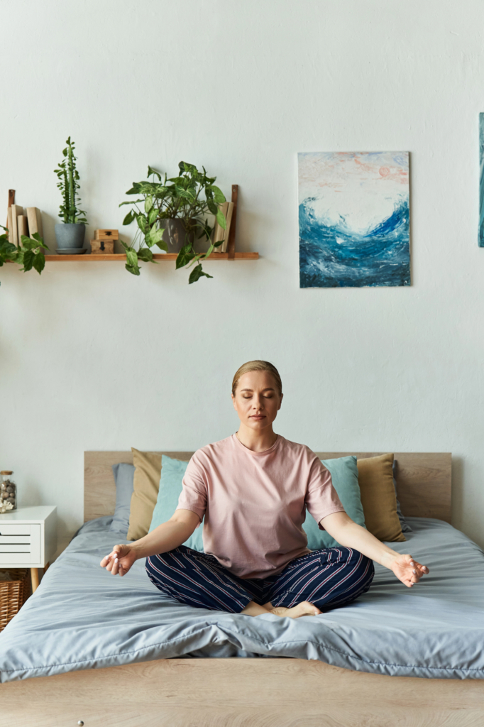 Nő otthon az ágyon ülve meditál