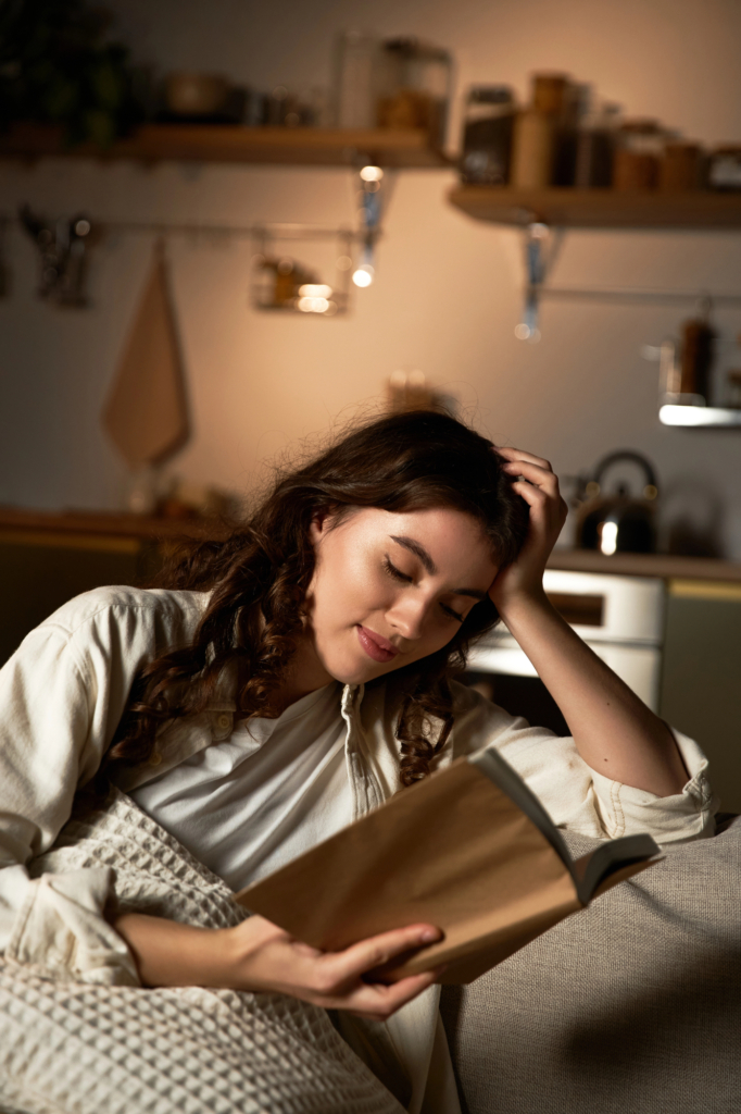 Nő este kis lámpafénynél olvasgat