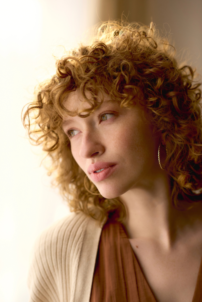 Göndör, vörös hajú nő elmélkedik