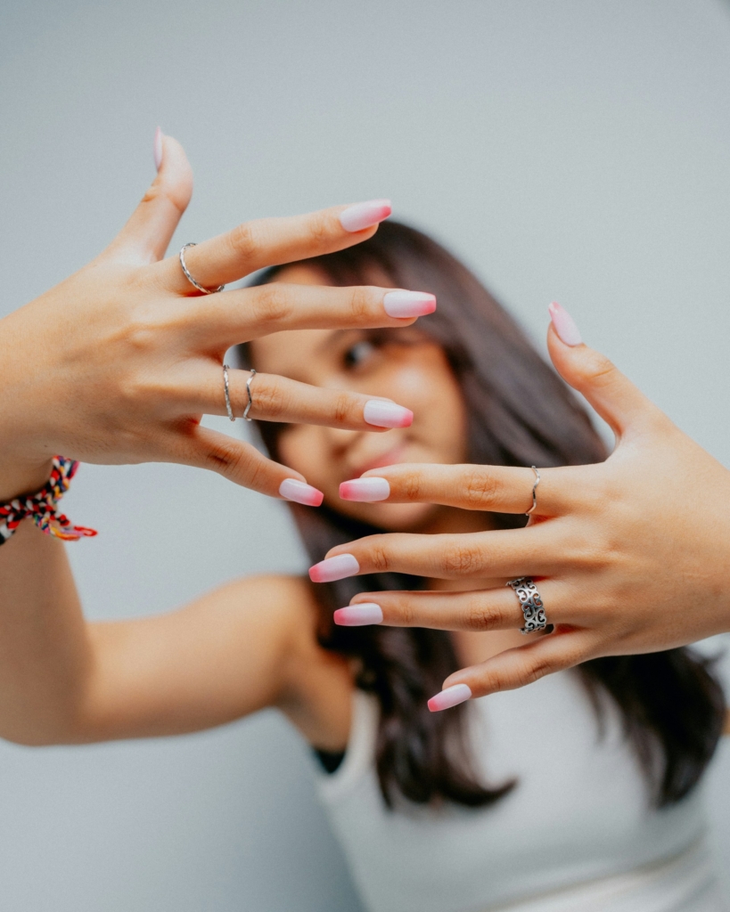 Fiatal lány mutatja a kamerába a körmeit