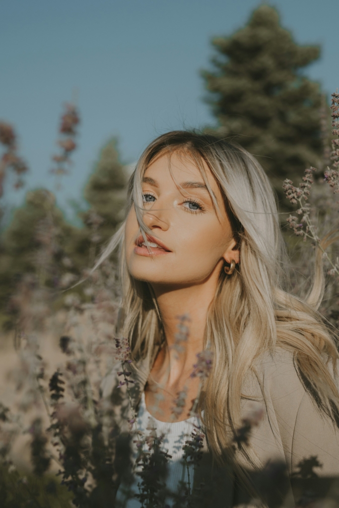 Szőke lány portréja egy virágos réten