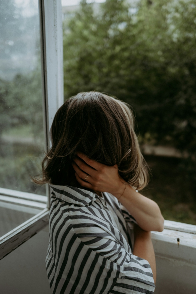 Nő néz ki az ablakon