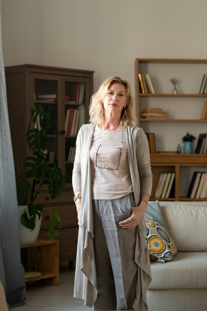 Középkorú nő áll az elegáns otthona nappalijában