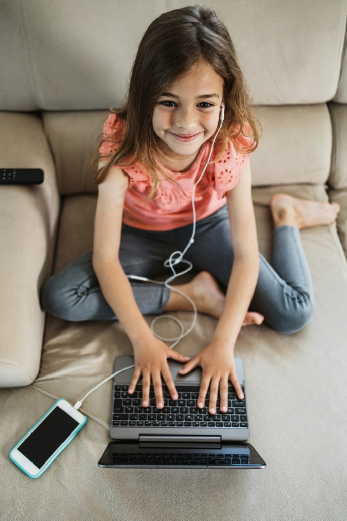 Kislány laptopozik és közben mobilról zenét hallgat