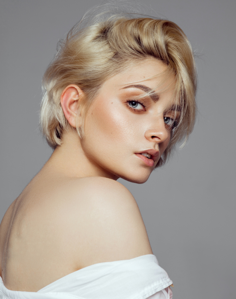 Szőke, pixie hajú nő oldalválasztékkal
