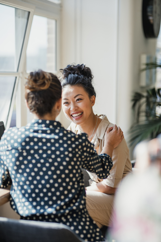 Nő beszélgetés közben megérinti a női beszélgetőpartnerét