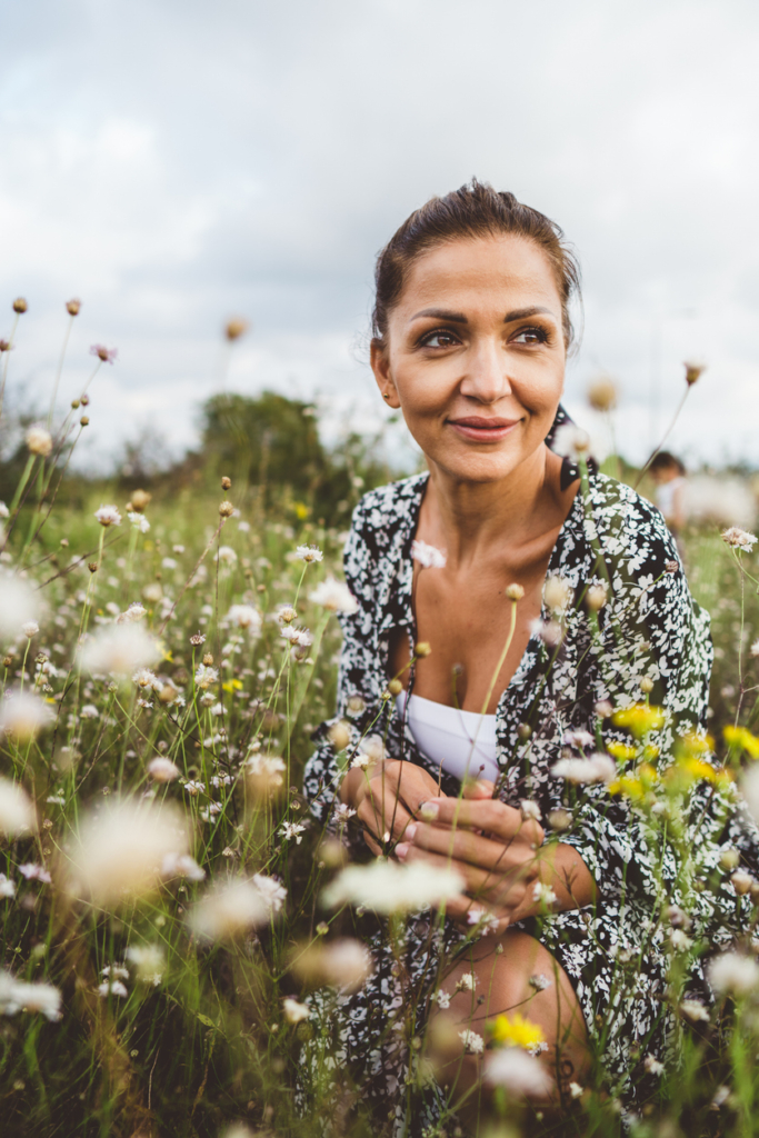 Nő sétál egy virágos réten