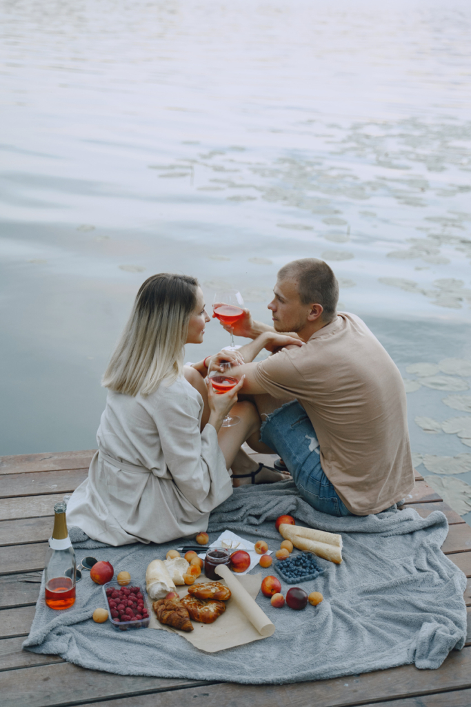 Pár egy romantikus piknik randevún a vízparton