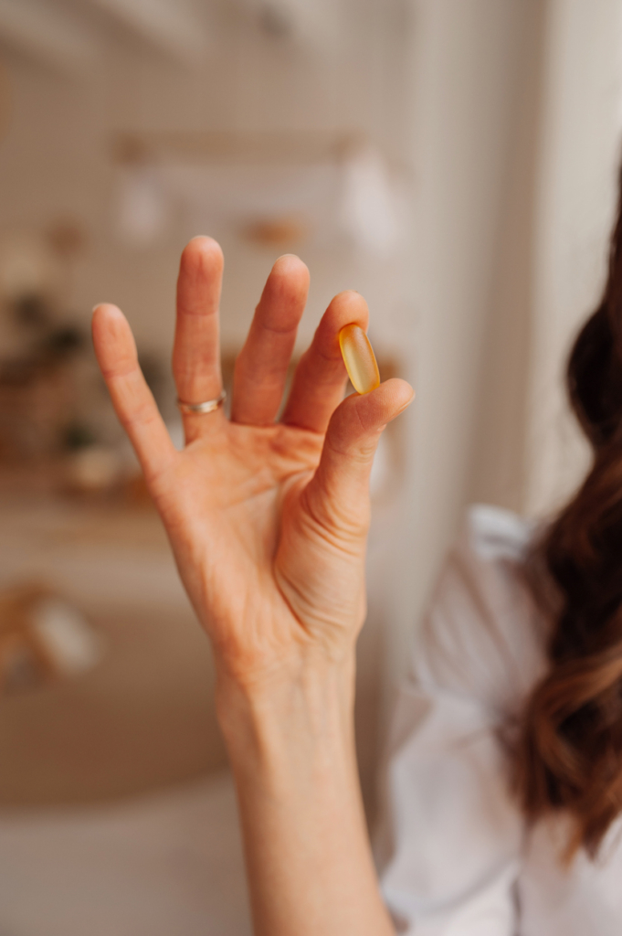 Nő egy tökmagolaj kapszulát tart a kezében