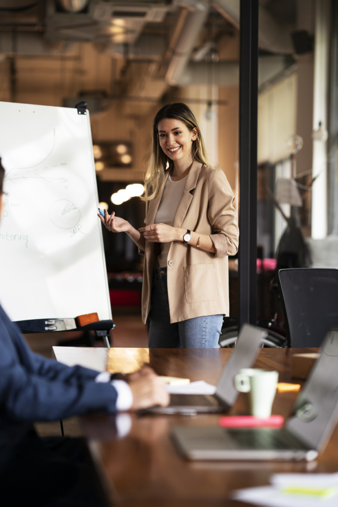 Frau präsentiert ihr Projekt im Meeting den Kollegen