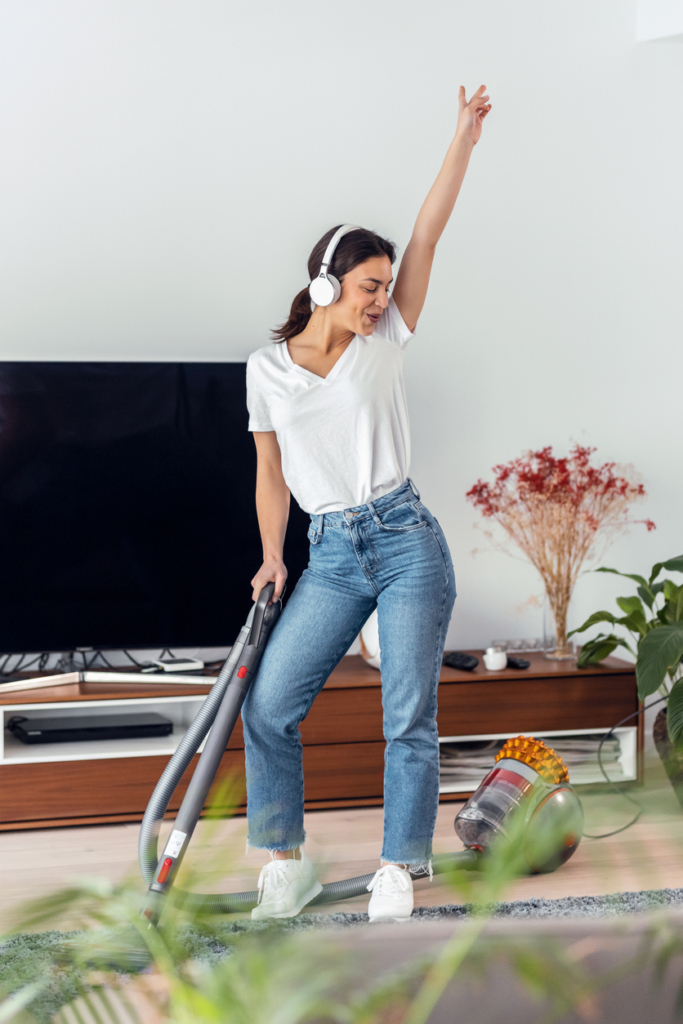 Femme qui danse en nettoyant avec un casque audio
