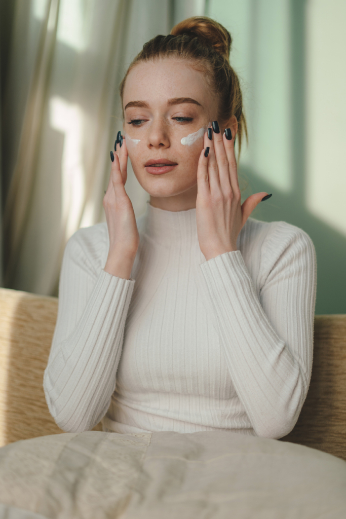 Fiatal lány UV krémet ken az arcára