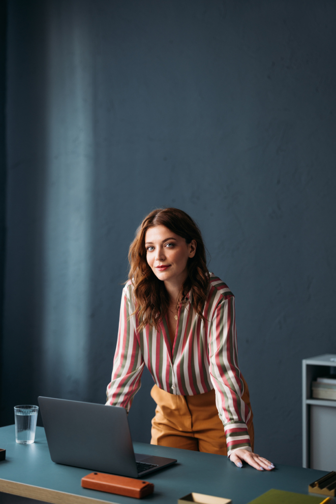 Üzletasszony a rendszerezett munkaasztala mellett áll