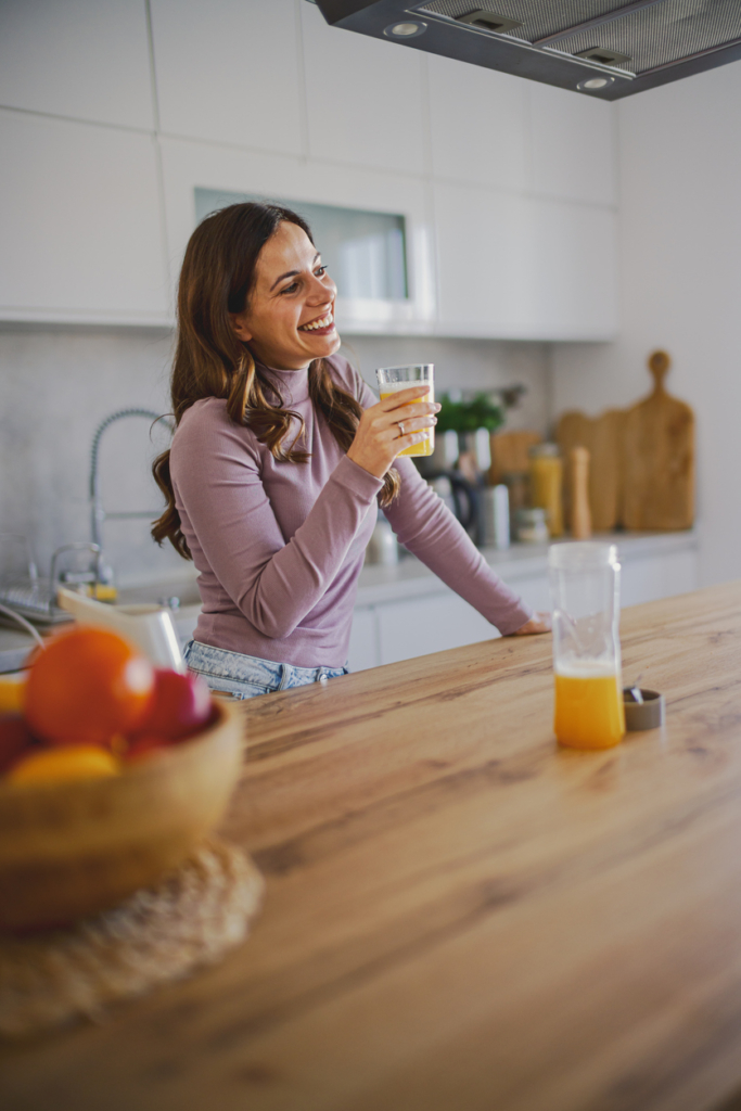 Nő smoothiet készít a konyhában