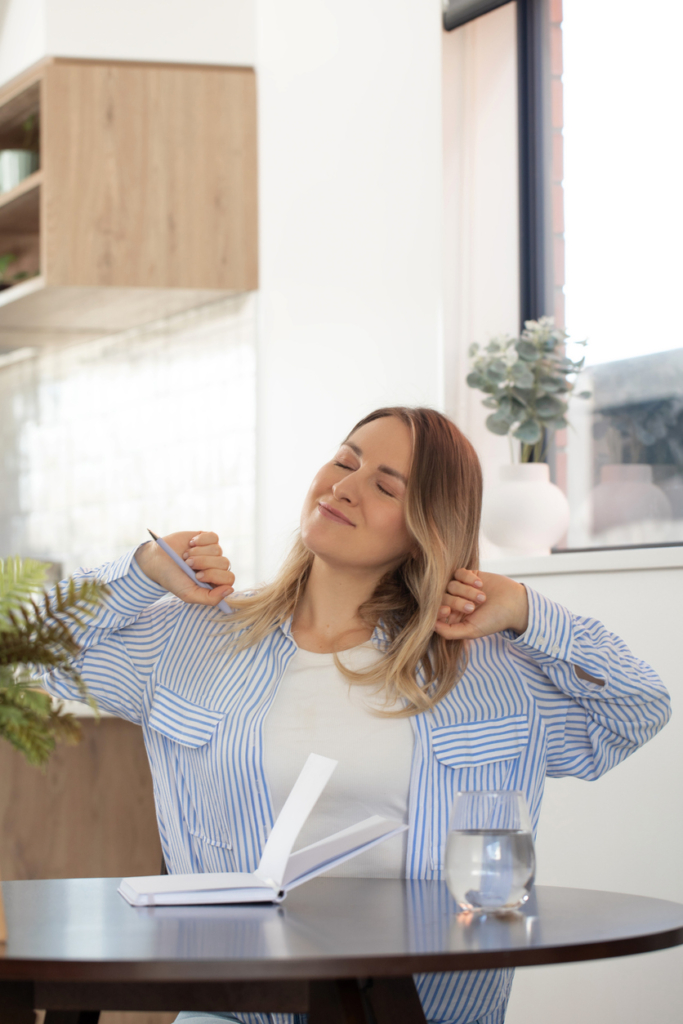 Nő elégedetten nyújtózik, miután végzett a munkával