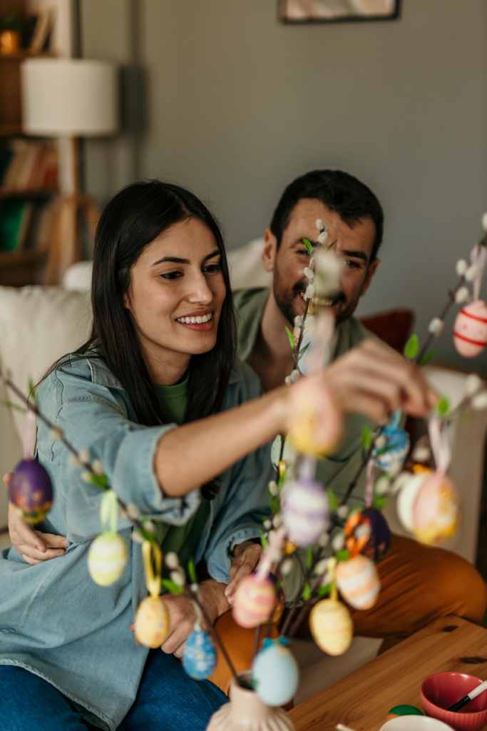 Jeune couple décorant un arbre à œufs ensemble