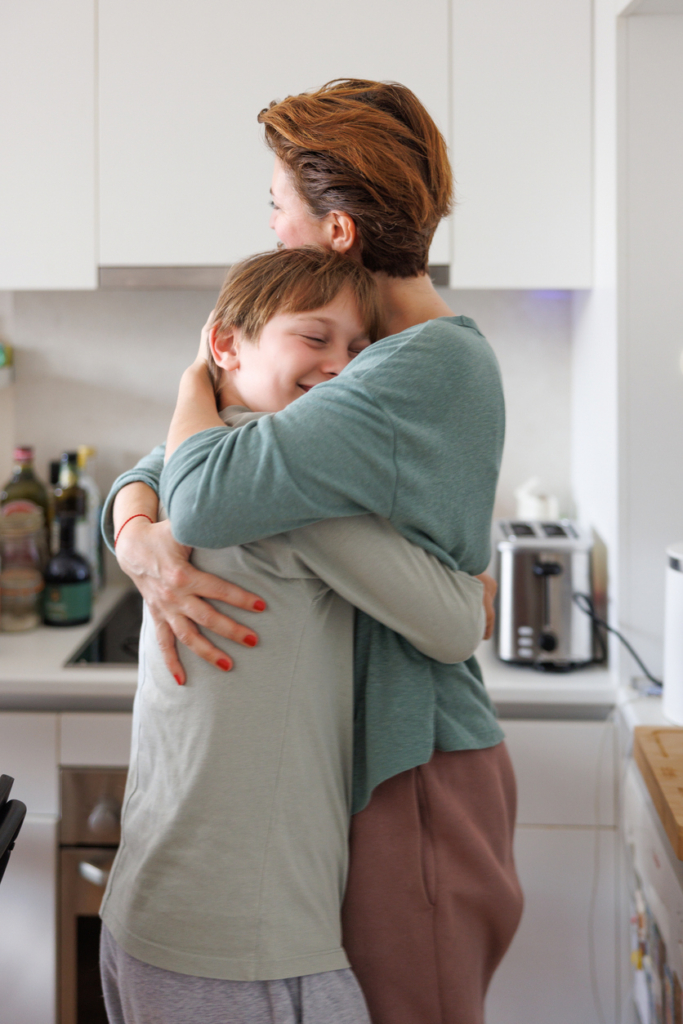 Madre abrazando a su hijo preadolescente