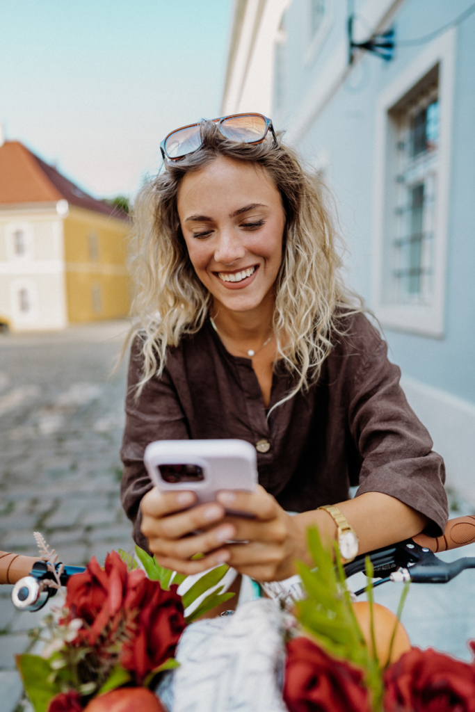 Mosolygós nő biciklizik a városban