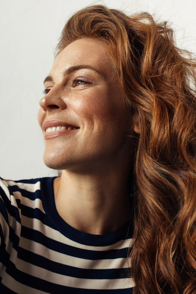 Vörös hajú nő mosolyog, portré