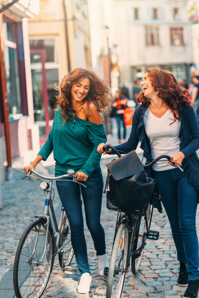 Amigas empujando sus bicicletas