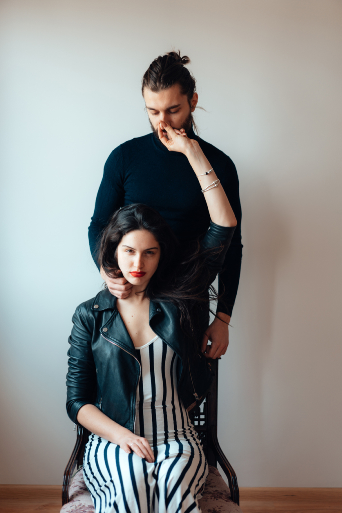 Nő egy széken ül, mögötte áll a férfi