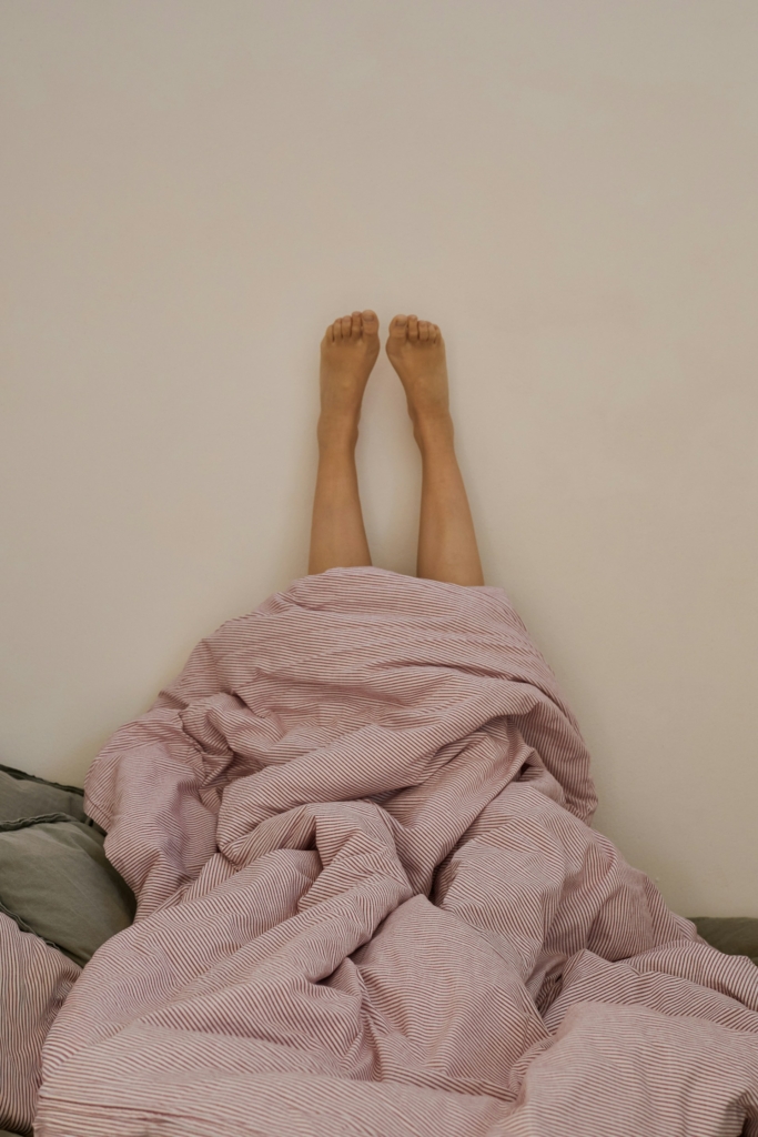 Nő a falra felrakott lábakkal fekszik