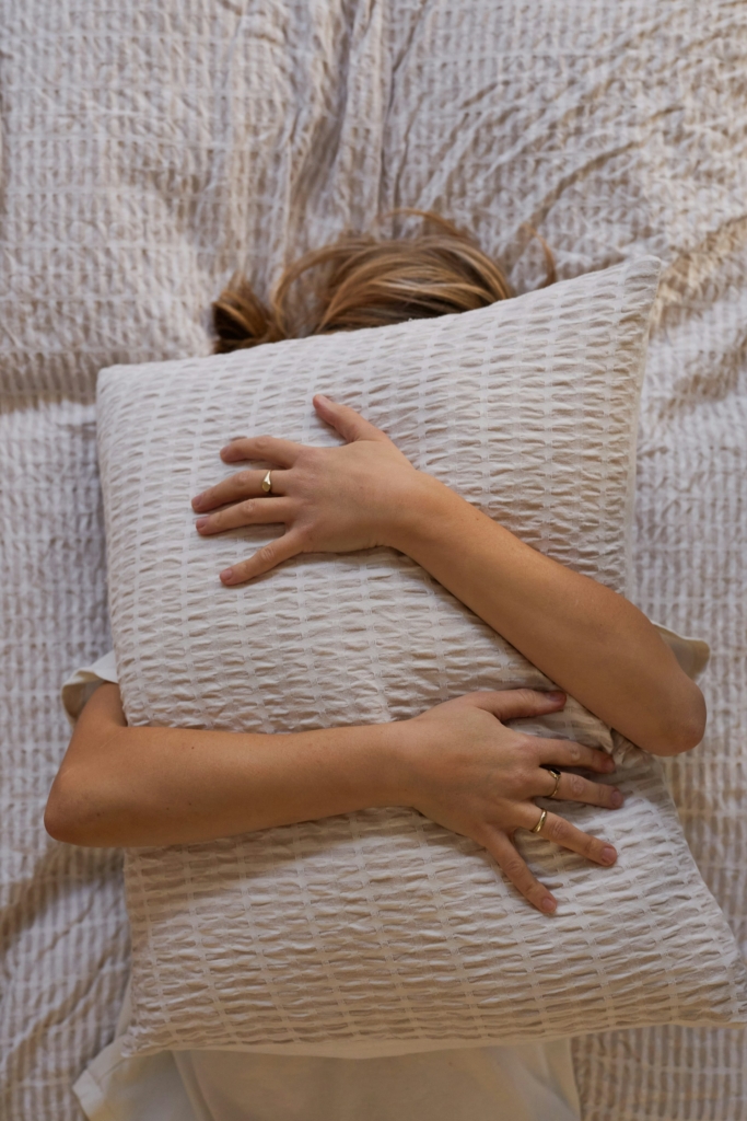 Nő magához ölel egy párnát