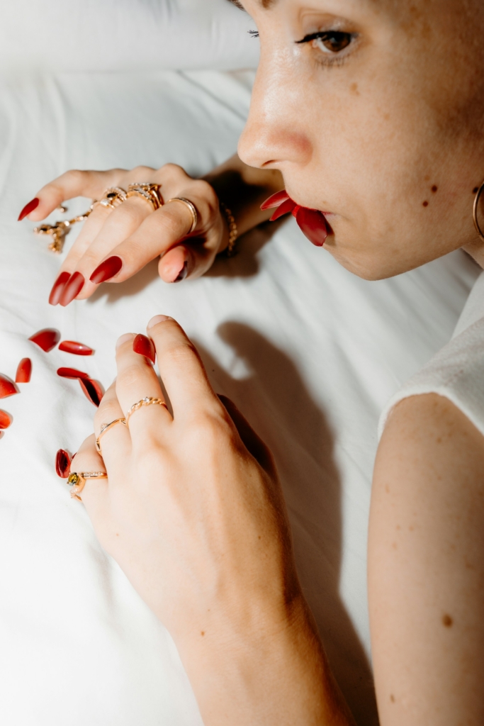 Nő letépkedi a műkörmeit, néhányat a szájában fog