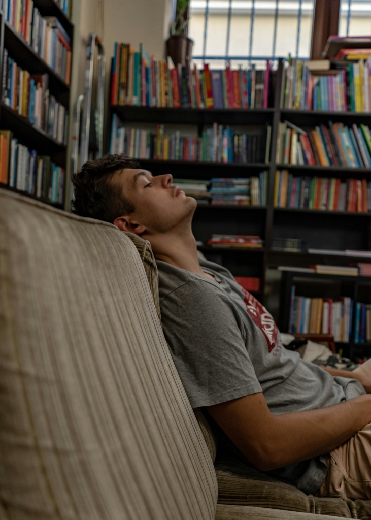 Kamasz fiú a könyvtárban pihen