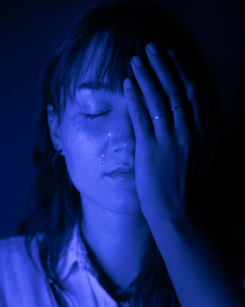 Portrait of a crying woman in blue light