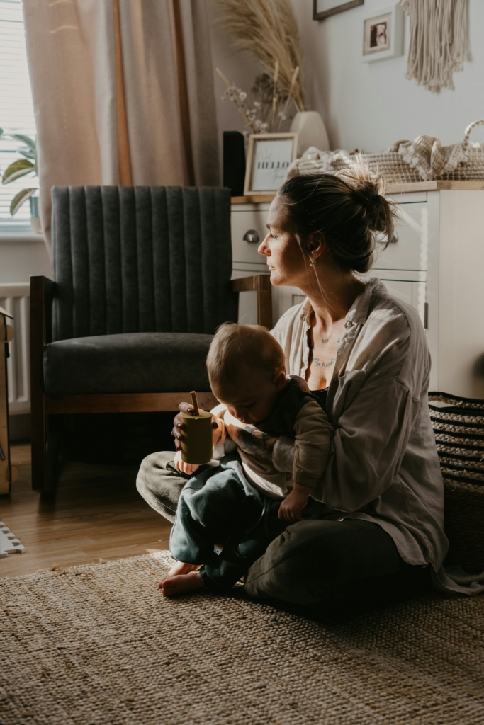 Anya fáradtan ül a sötét szobában a csecsemőjével