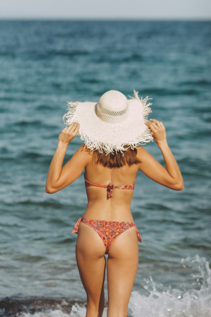 Bikinis nő a vízparton áll
