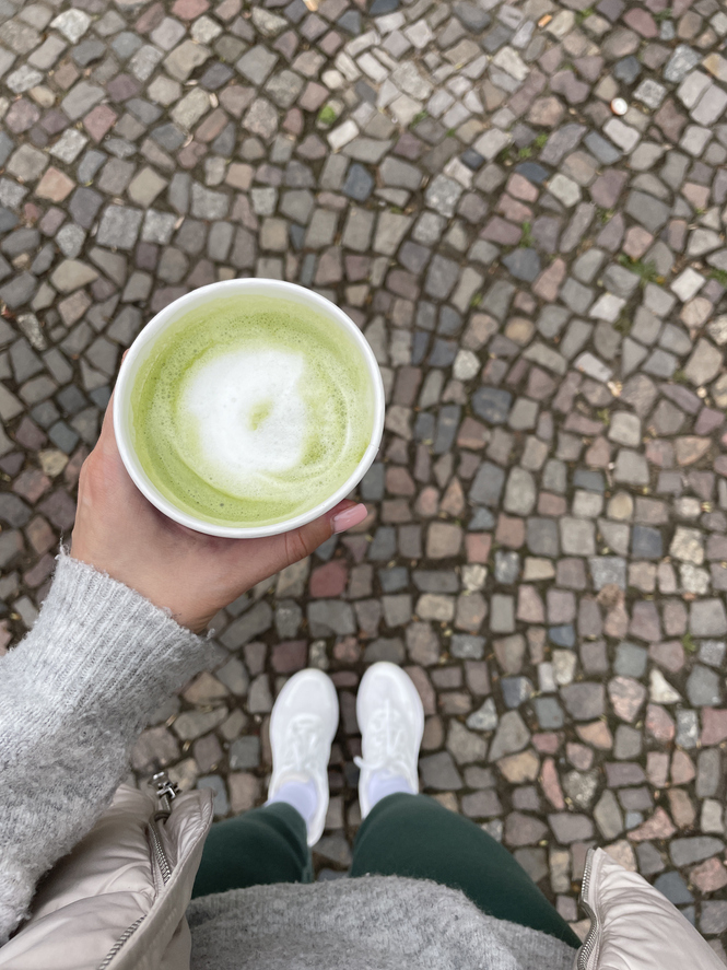 Női kézben egy matcha latte
