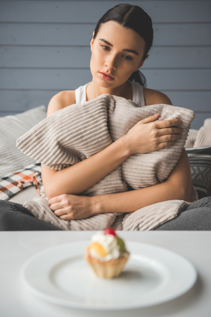Nő sóvárogva néz egy muffint