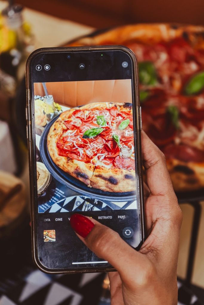 Nő lefotózza a pizzáját az Instára