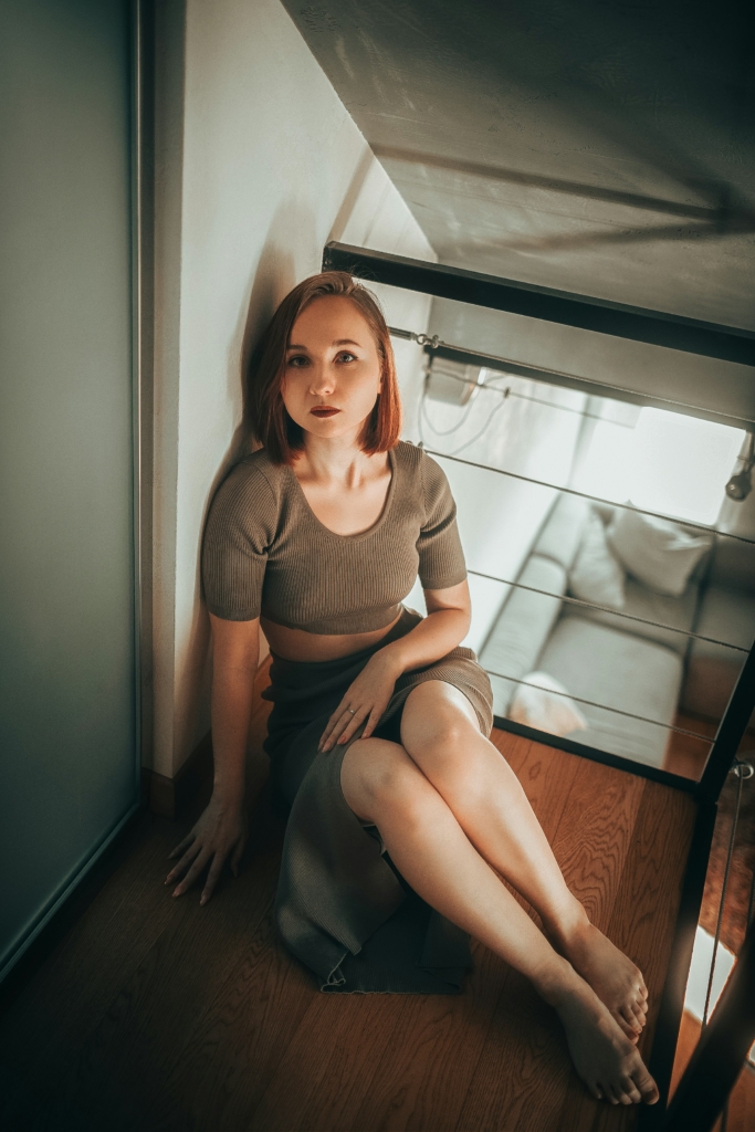 Frau sitzt auf dem Parkettboden