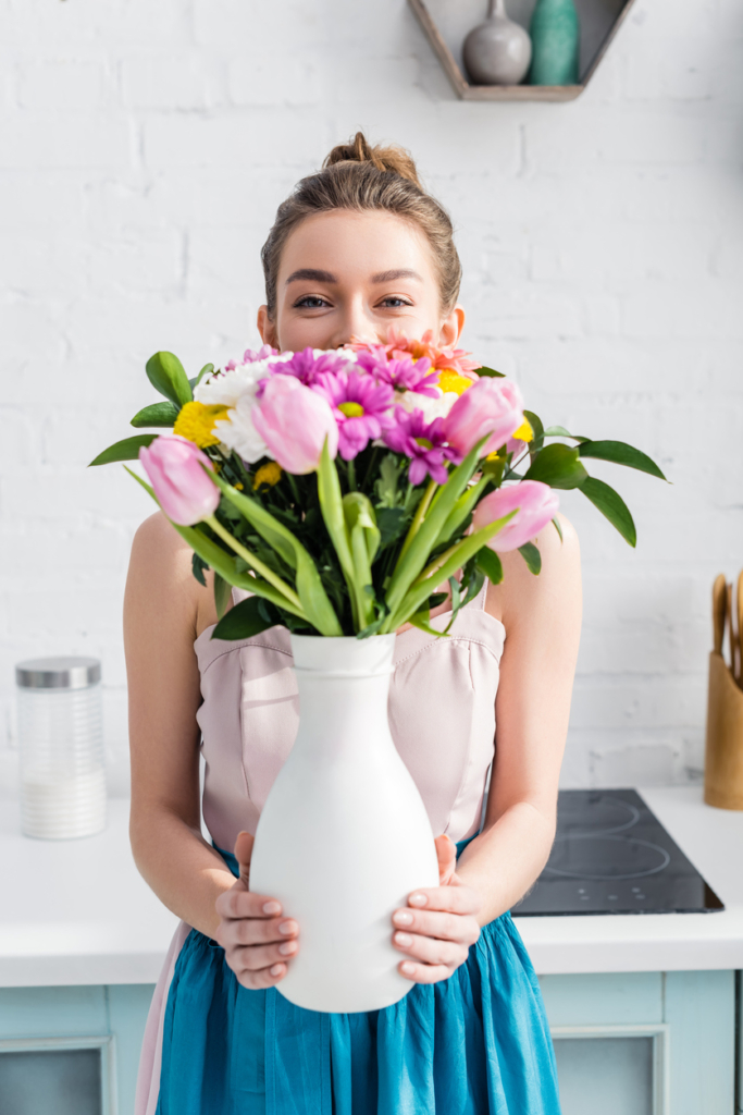 Donna sorridente con un vaso di fiori