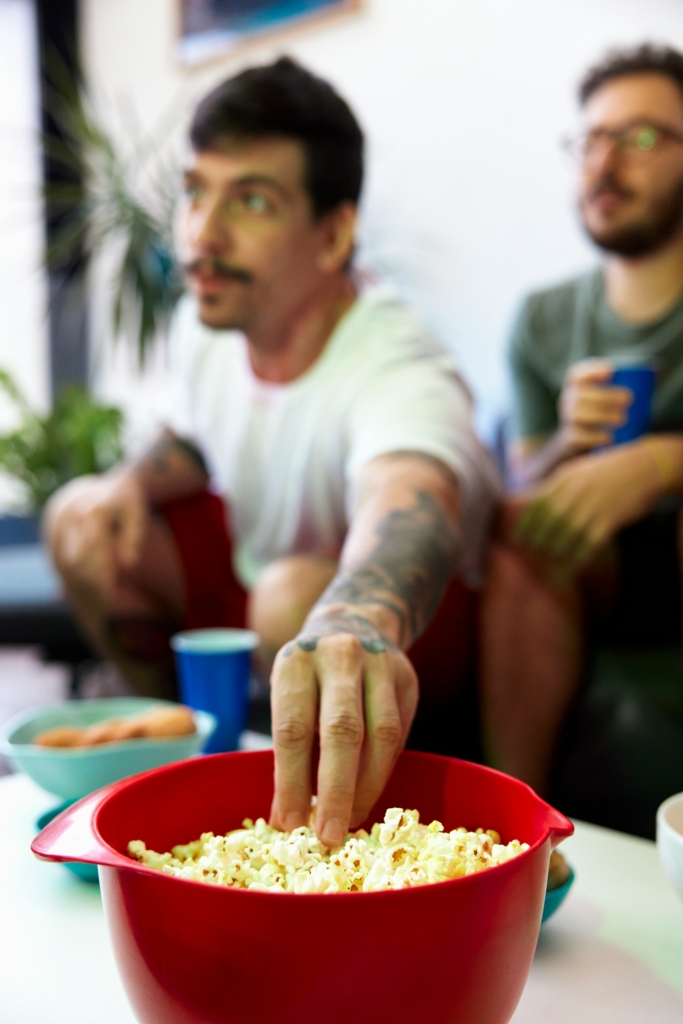 Férfi a popcornos tálba nyúl