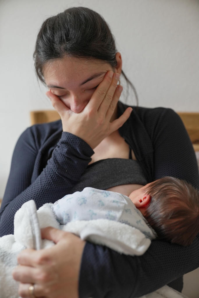 Anya ölében a babájával, közben a szemeit dörzsöli