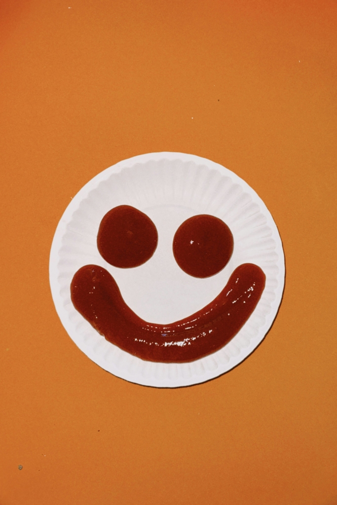 Ketchup mosolygós arc formában kinyomva egy papírtányérra