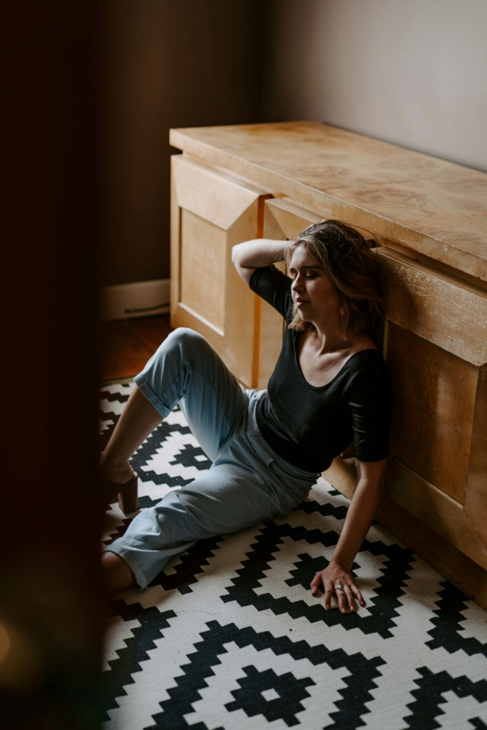 Stresszes, túlterhelt nő ül a konyhapadlón