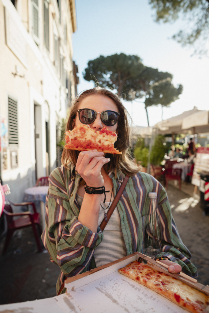 Nő egy szelet pizzát eszik útközben