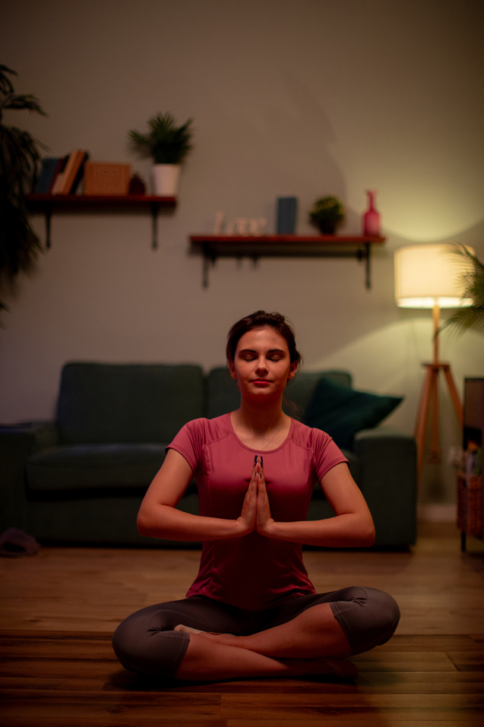 Nő este csendesen meditál a szobában